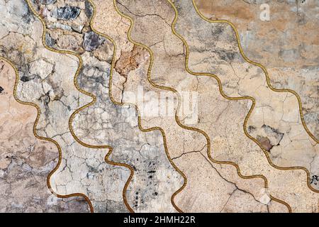 Old, faded and cracked wall collage with golden frames. Concrete, cement and golden wall pattern. Asymmetric and wavy abstract textured Background. Stock Photo