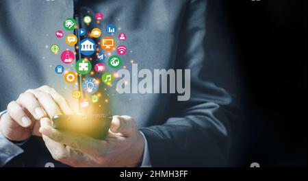 Man holding smartphone with technology application icons Stock Photo