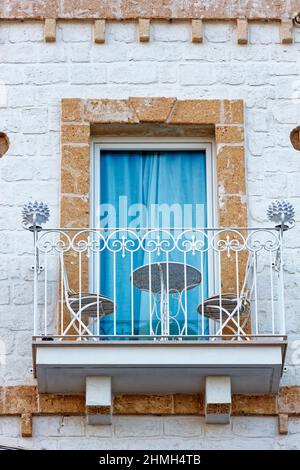 Two chairs and a table are on a balcony Stock Photo