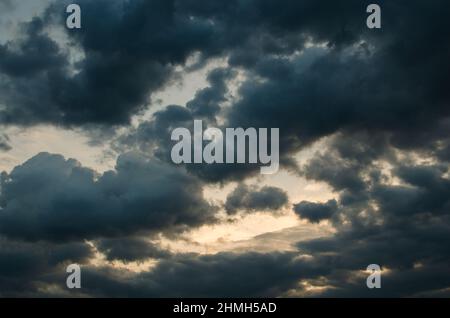 Bright Cumulus clouds in sunset light after the rain Stock Photo