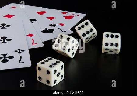 Dice, playing cards on a black background thrown on the table Stock Photo