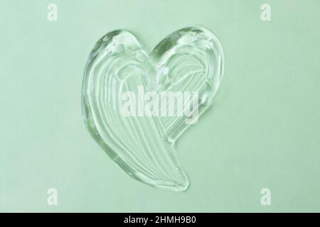 Cosmetic gel in shape of heart on the mint background.Copy space for text,mockup concept. Stock Photo