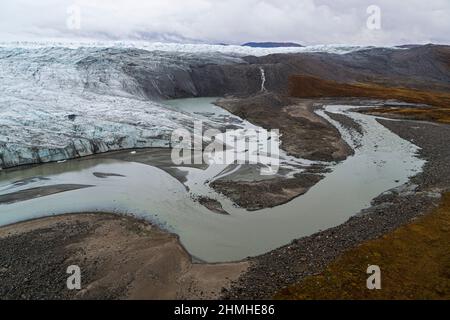 Drone image of the glacier front, meltwater lake, meltwater flow and autumnal arctic environment of the increasingly dynamically melting Russell Glacier in western Greenland with a view of the arctic hinterland. Stock Photo