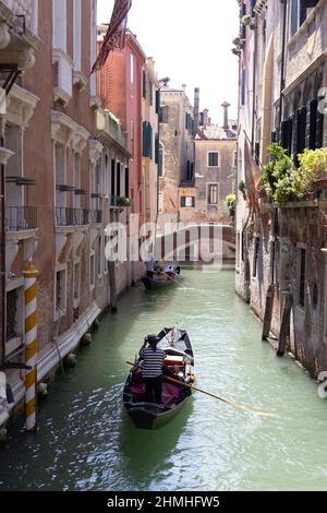 Two gondolas traveling down a small canal in Venice, Italy Stock Photo