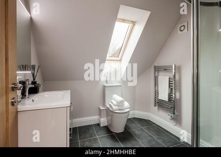 Newport, Essex - March 21 2019: Luxury modern shower room and wc with chrome towel rail within brand new staged home. Stock Photo