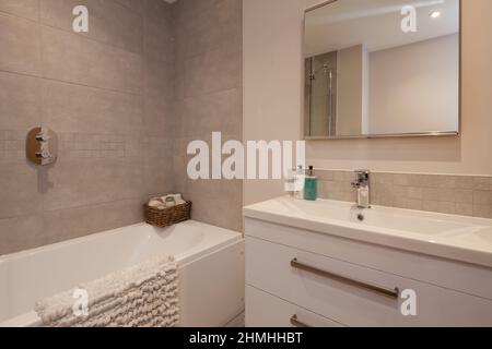 Newport, Essex - March 21 2019: Luxury modern bathroom and wc with partially tiled walls in brand new staged show home. Stock Photo