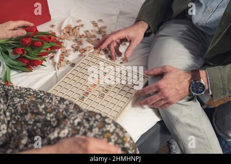 caucasian middle-aged man playing vocabulary games with his elderly mother durimong Mother's Day. High quality photo Stock Photo