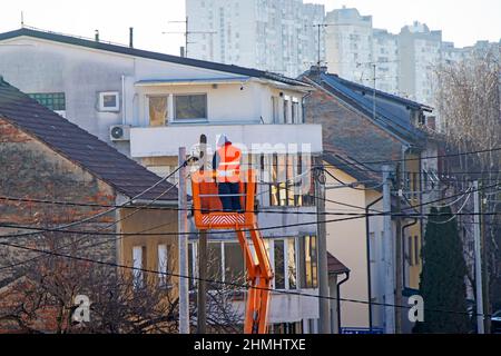 Electrician worker on a pole, repairing power lines Stock Photo