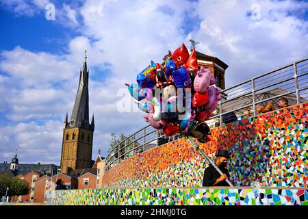 Colourful scene at the Rhine river promenade in Düsseldorf/Germany. Mosaic tile wall by Hermann-Josef Kuhna. Lambertus church in the background. Stock Photo