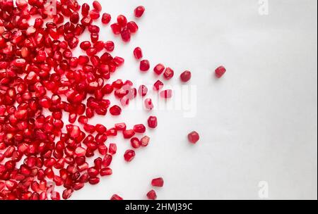 Fresh pomegranate seeds scattered on white background. Healthy food. Stock Photo