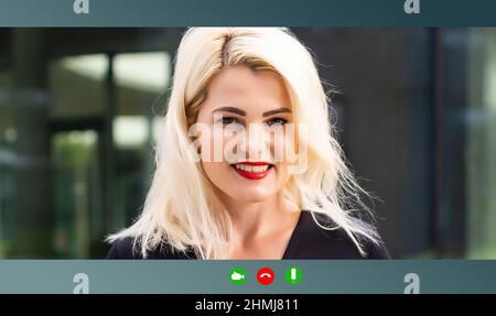 Positive beautiful influential Caucasian mature woman, top company manager talking online with client or employees, discussing project, holds Stock Photo