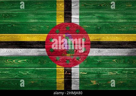 The national flag of Dominica is painted on a camp of even boards nailed with a nail. The symbol of the country. Stock Photo