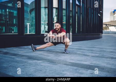 Man doing side lunge during workout Stock Photo