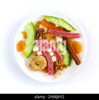 Dried fruits and nuts in white plate on white background Stock Photo