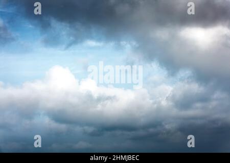 High resolution background with blue day time sky and white and black clouds. Dramatic sky overly. Soft focus. Stock Photo