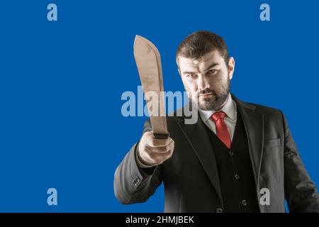 The killer swings at his victim. Dangerous man. Threat to life. The maniac is trying to kill a man. A bearded man in a suit with a red tie with a long Stock Photo