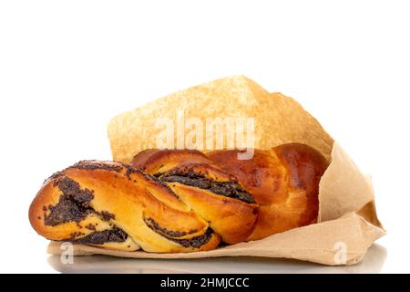 One flavorful homemade poppy seed bun with a paper bag, macro, isolated on a white background. Stock Photo