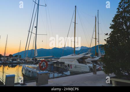 Yachts moored in the port on the background of the evening sunset.Swimming and travelling. Stock Photo