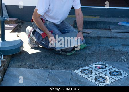 Laying ceramic floor tiles - man hands closeup Stock Photo