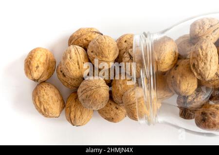 Whole solid walnuts in a jar on white background Stock Photo
