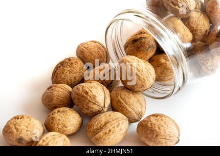 Whole solid walnuts in a jar on white background Stock Photo