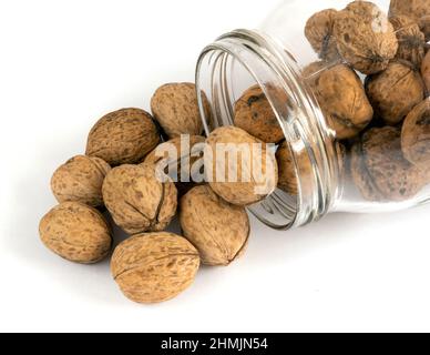 Whole solid walnuts in a jar on white background Stock Photo