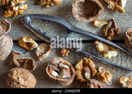 Walnuts and nutcracker on wooden background Stock Photo