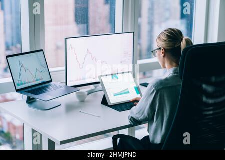 Faceless woman analyzing charts in office Stock Photo