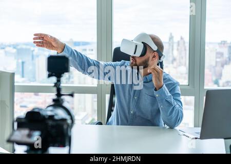 Serious businessman in VR glasses in office Stock Photo
