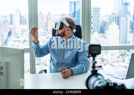 Focused bearded businessman in VR goggles in office Stock Photo