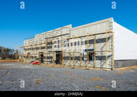 Horizontal angled shot of new retail construction with scaffolding across the front. Stock Photo