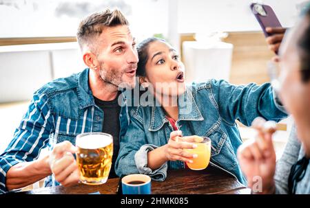 Couple in love taking selfie at brewery on brunch time - Young happy friends enjoying cool fun moments at restaurant bar patio - Life style concept wi Stock Photo