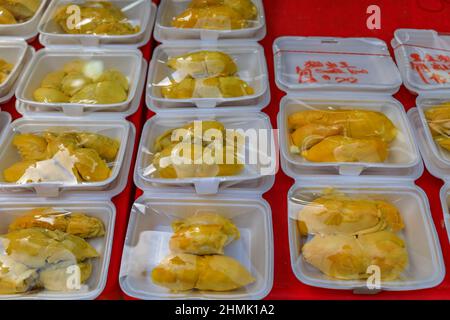 Street food vendor or hawker stall with cut and packaged durian fruit on display in Singapore Stock Photo