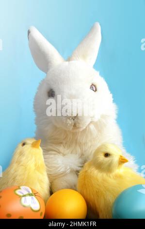 Easter bunny rabbit with painted eggs and chick on blue background. Easter holiday concept Stock Photo