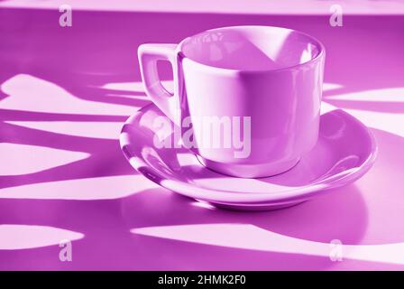 White cup of coffee on pink background ,  long shadows on cup , break time Stock Photo
