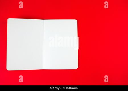 Empty blank paper notebook or book mockup on red background. White empty paper notepad Stock Photo