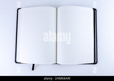 Opened lined blank paper book on white background. Mock up or copy space. Empty notebook with lines for diary, notes or sketches Stock Photo