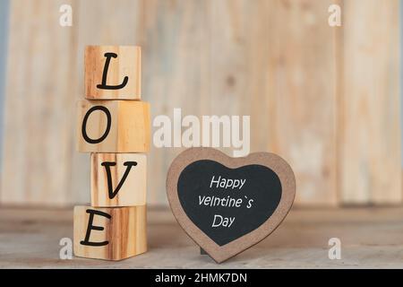 wooden blocks in vertical with the word I love you and a blackboard heart with the phrase Stock Photo