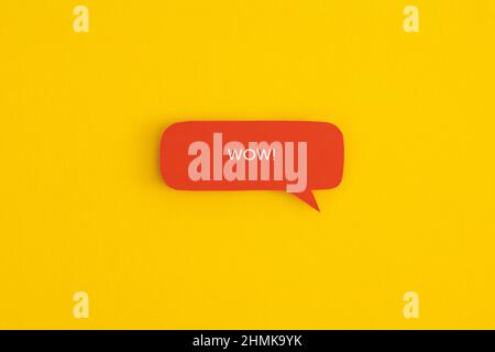 Paper speech bubble with the word "Wow" on a yellow background. Top view with copy space. Flat lay. Stock Photo