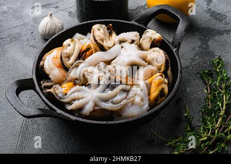 Raw mix seafood cocktail with shrimps, prawns, mussels, squids set, on gray stone table background Stock Photo