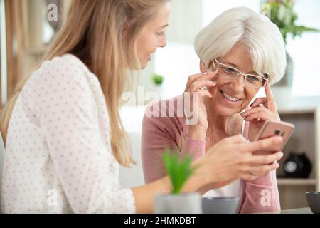 young girl explains elderly woman how to use her phone Stock Photo