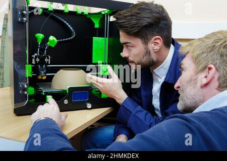 two male engineers working with 3d printer Stock Photo