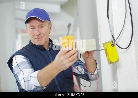 experienced electrician doing electrical work with high precision and neatness Stock Photo