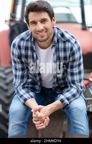 portrait of a farmer sitting on a tractor smiling Stock Photo