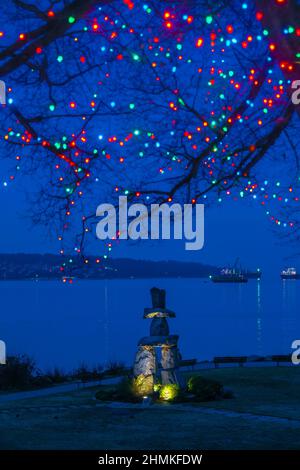 Inukshuk and Christmas lights, Elm Grove, English Bay, Vancouver, British Columbia, Canada Stock Photo