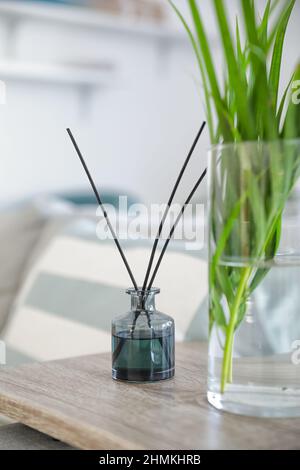 Aroma reed diffuser with vase on table in room Stock Photo