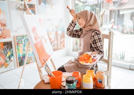 muslim female artist while working in her project at studio Stock Photo