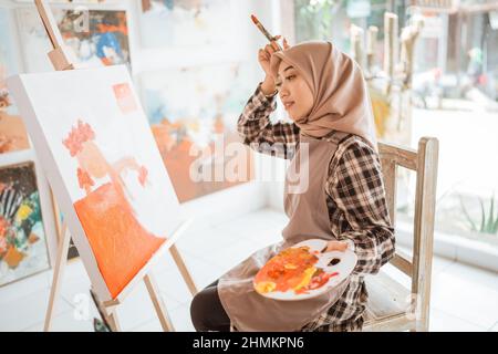 muslim female artist while working in her project at studio Stock Photo