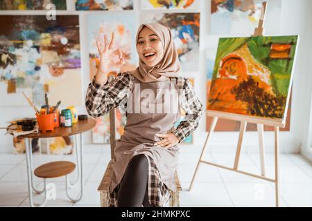 muslim asian female artist showing thumb up Stock Photo