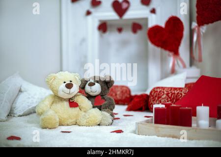 Romantic setting. Two cozy toys bears with hearts. Candles burning Stock Photo